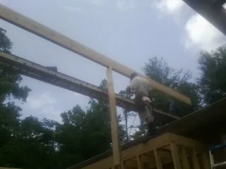 Carpenter setting a ridge beam over a new addition frame — Ice Dam Removal by Roofing Brothers in Shrewsbury