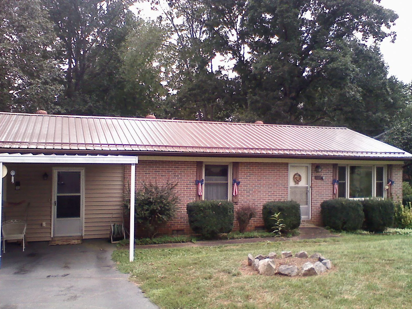 Bronze metal roof and carport on a brick ranch home — Roof Repair work by our crew in Shrewsbury